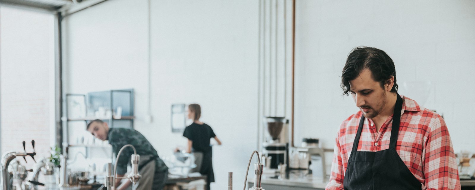 A barista in an apron at work behind the counter