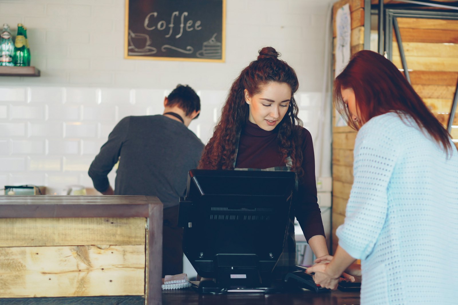 Staff serving a customer at a caf&eacute; counter